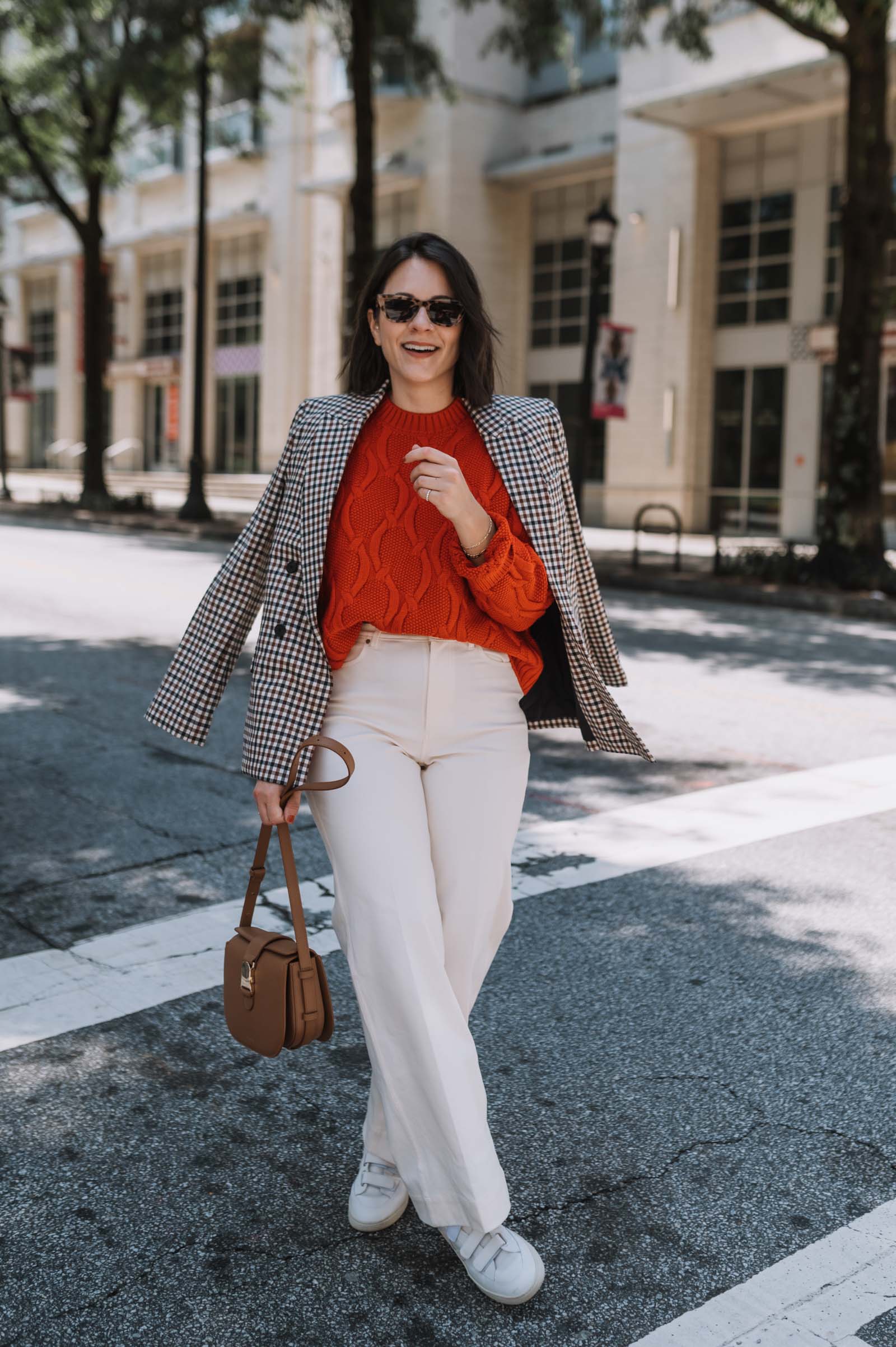 white trouser jeans with a sweater and leather sneakers