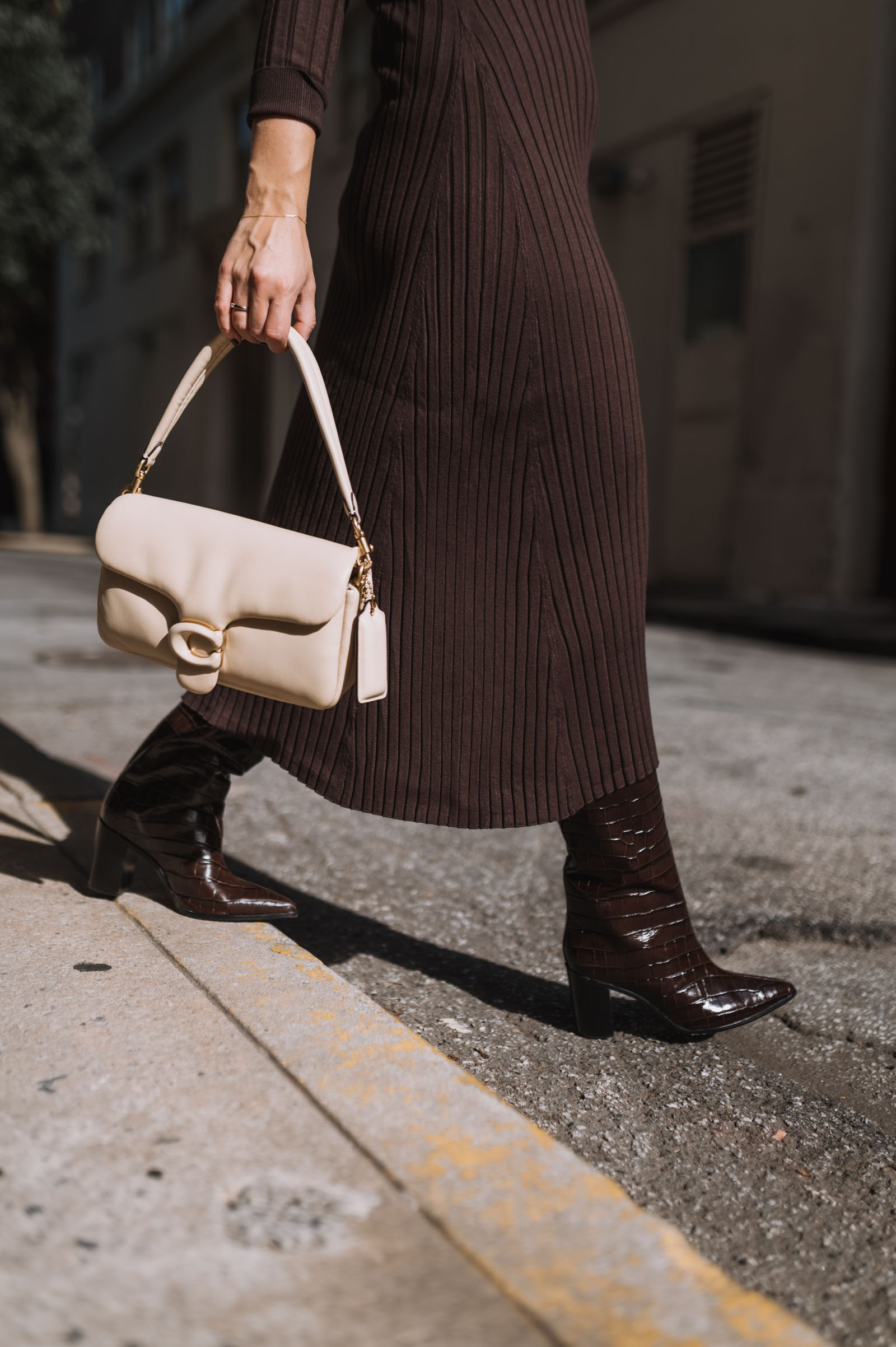 brown boots with a brown dress and cream leather bag