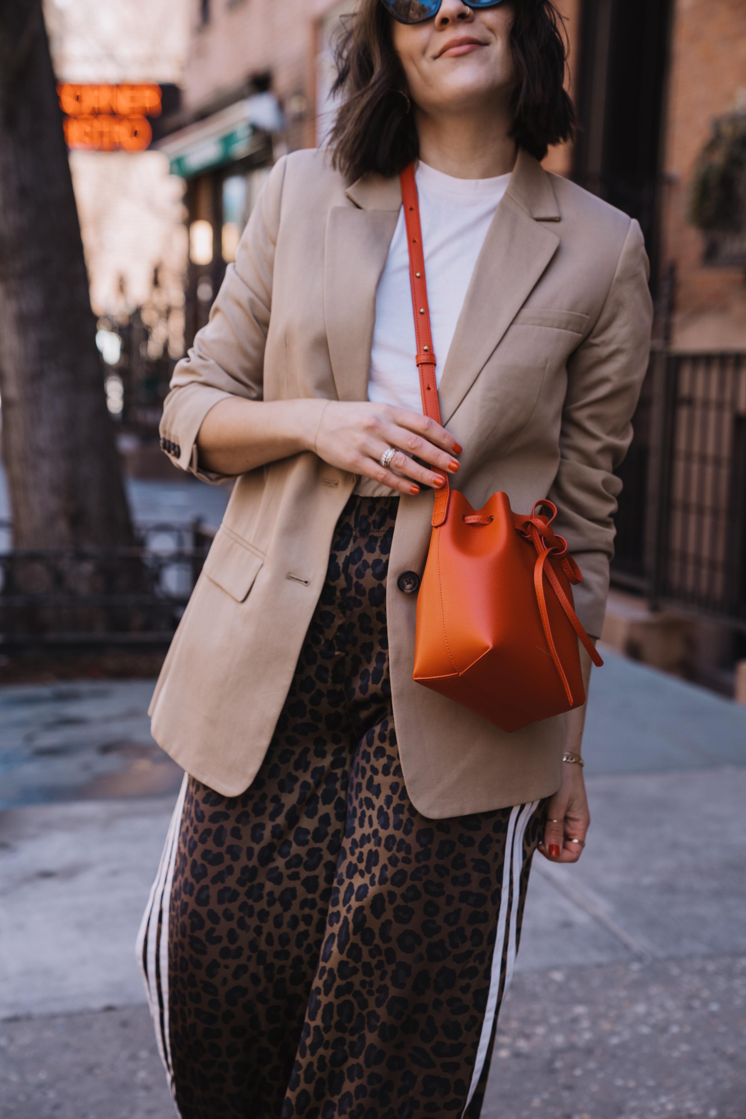 leopard adidas track pants and a red bag with a blazer